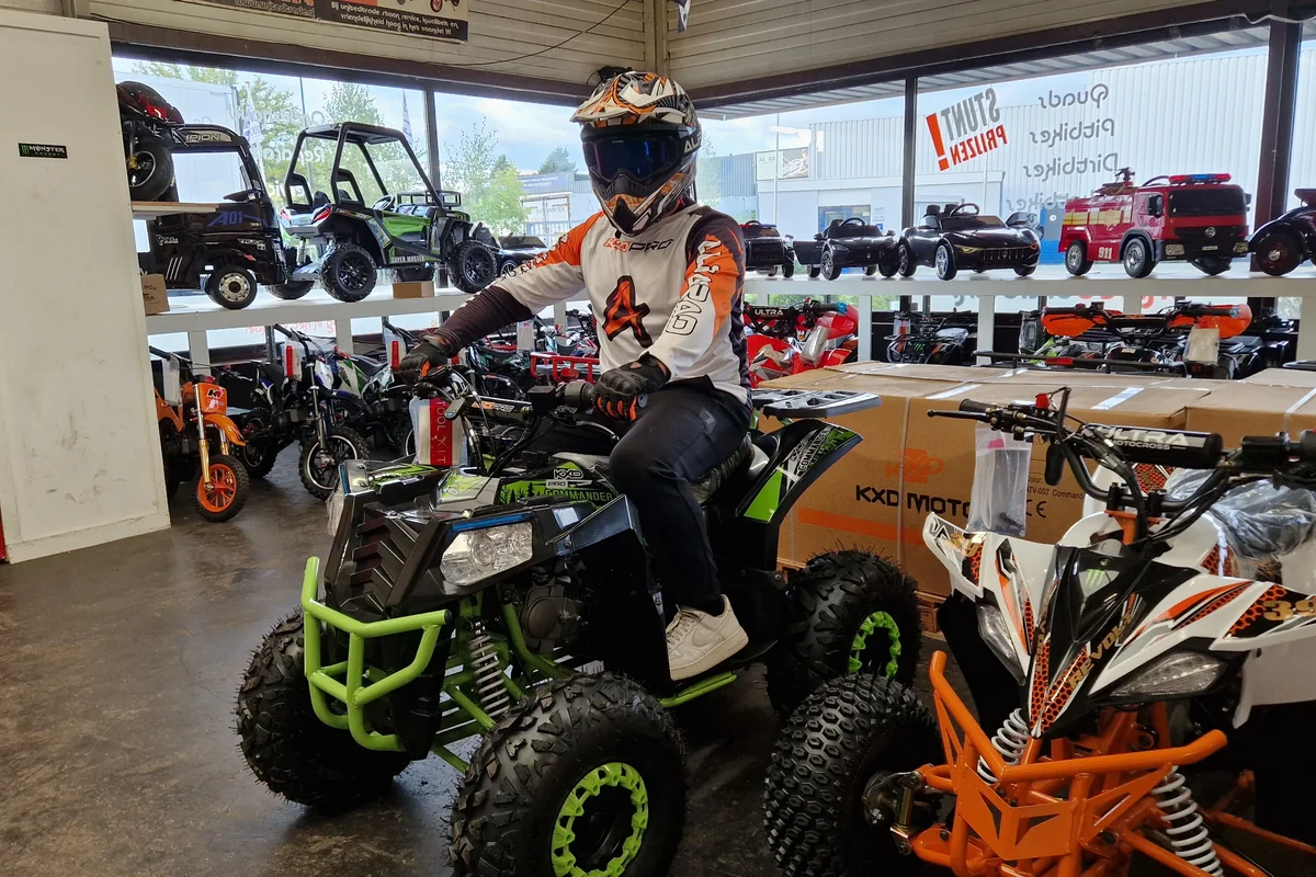 Groene quad met rijder in de showroom