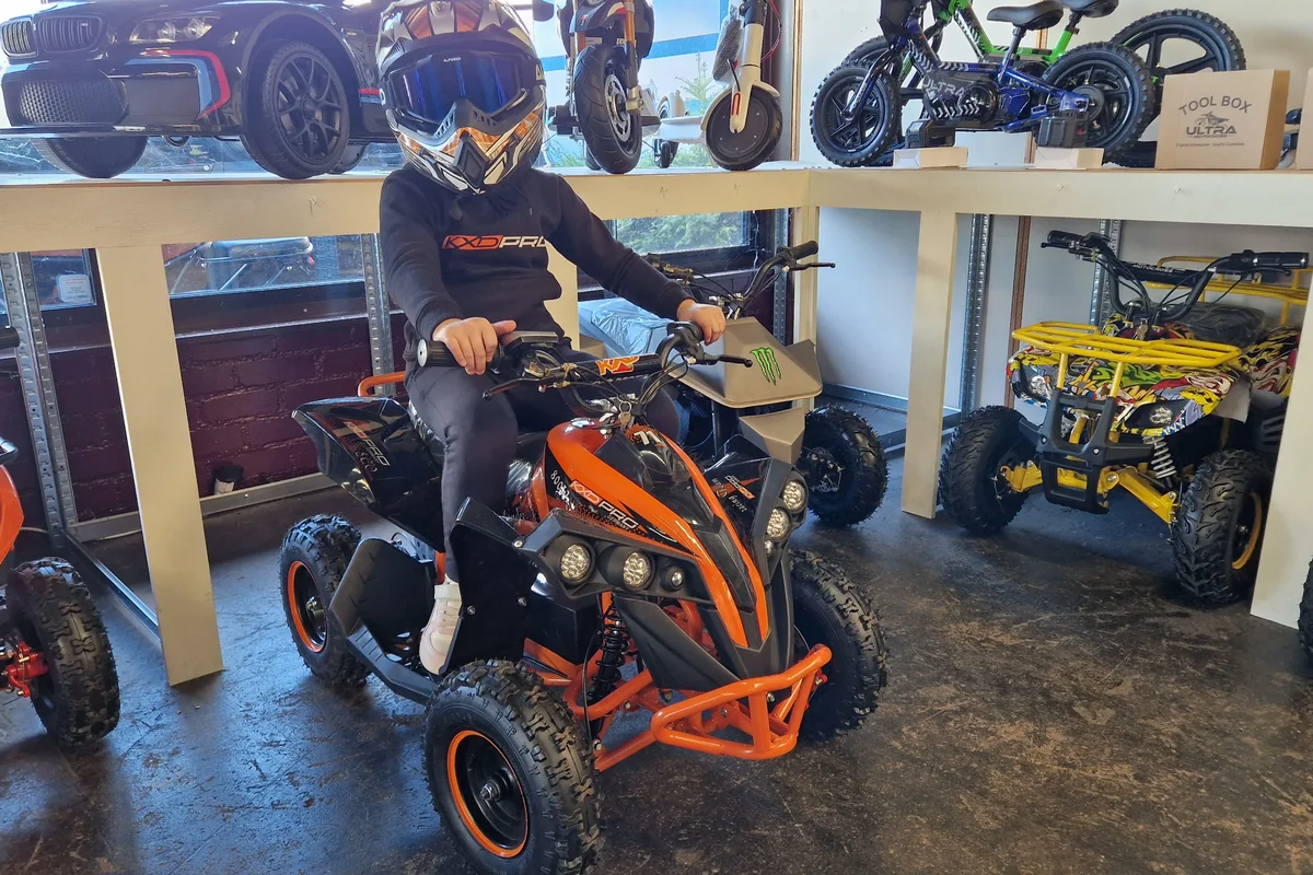 Oranje kinderquad met jonge rijder