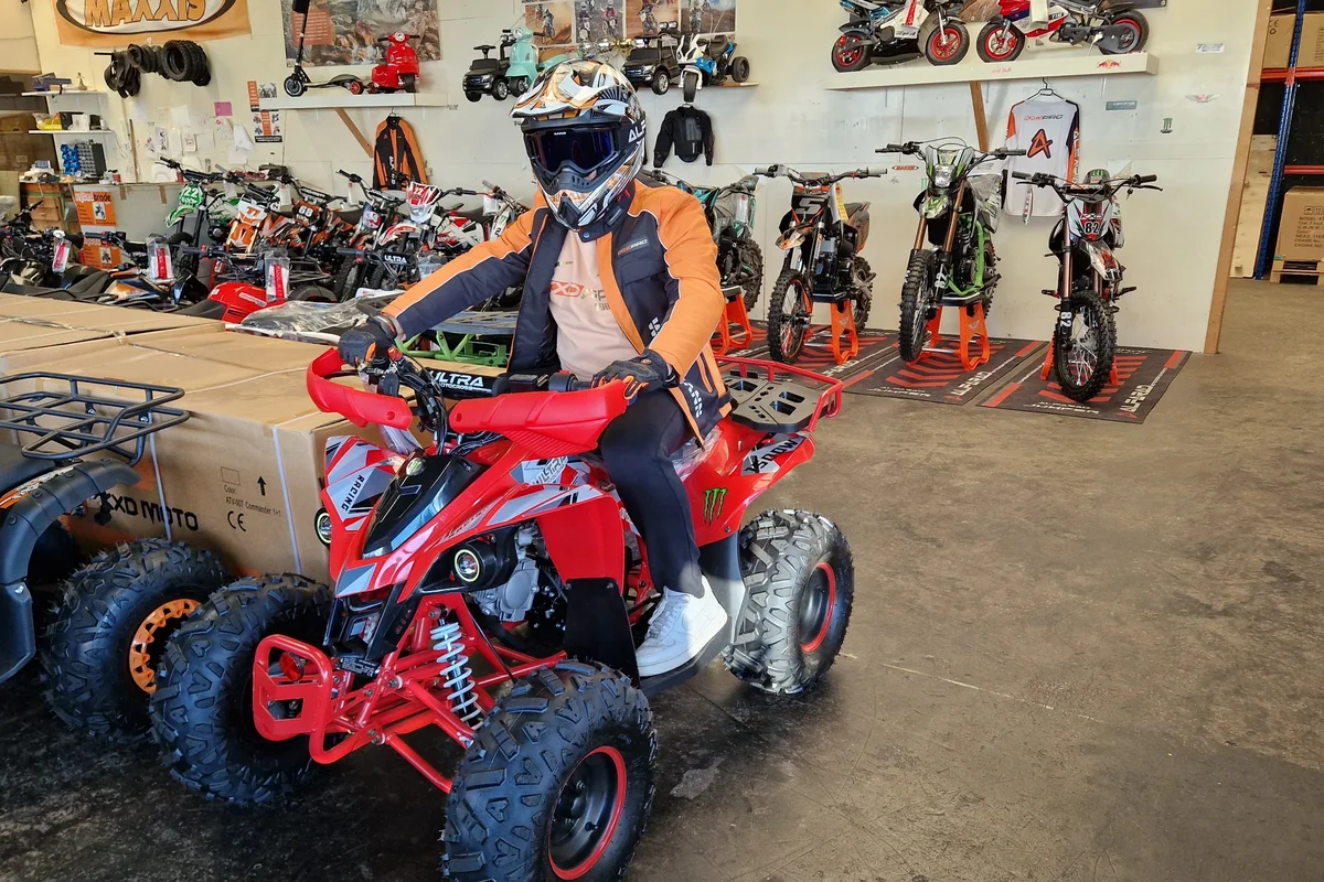 Rijder op een rode quad in de showroom