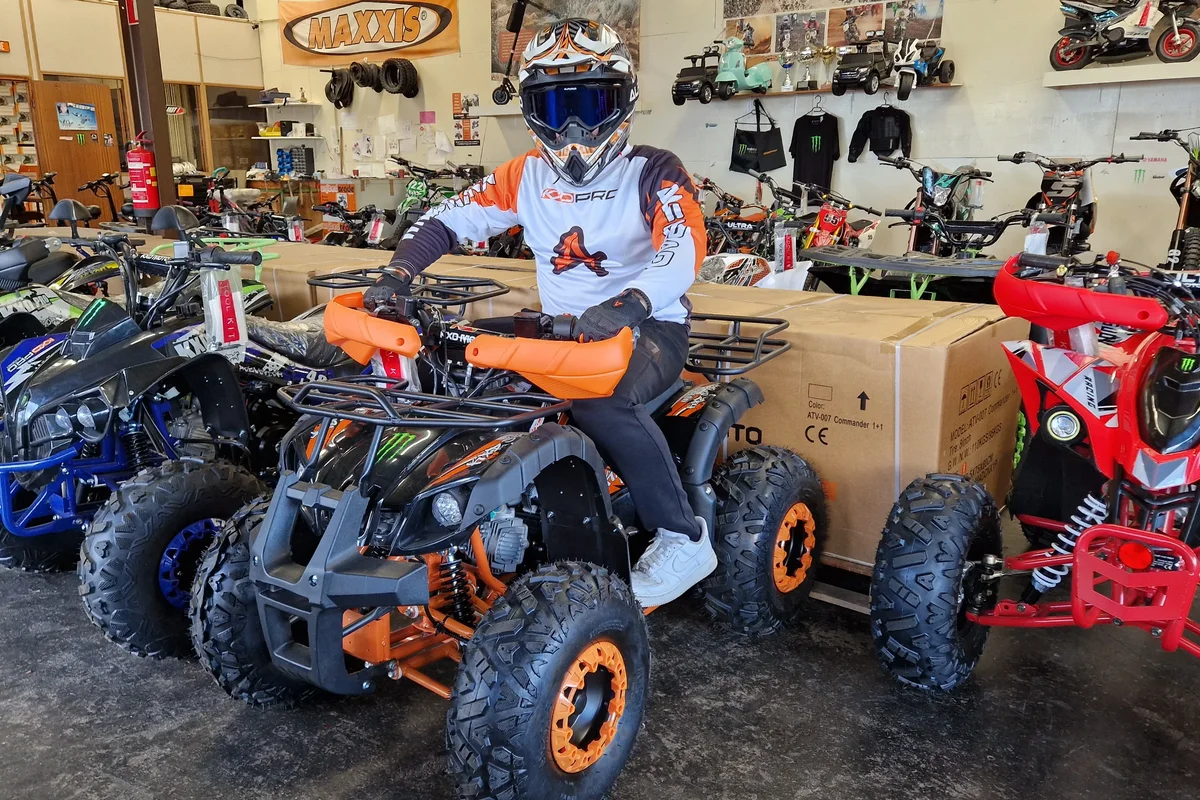 Zwarte quad met oranje velgen en rijder