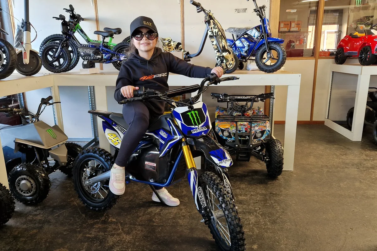 Blauwe elektrische dirtbike met lachende rijder