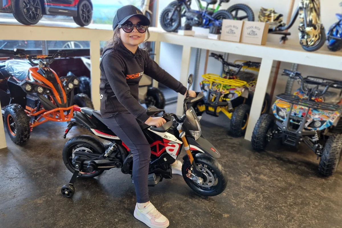 Wit-rode elektrische kindermotor met zijwieltjes