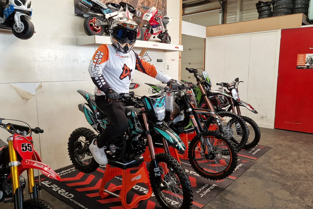 Groene dirtbike op een rood podium in de showroom