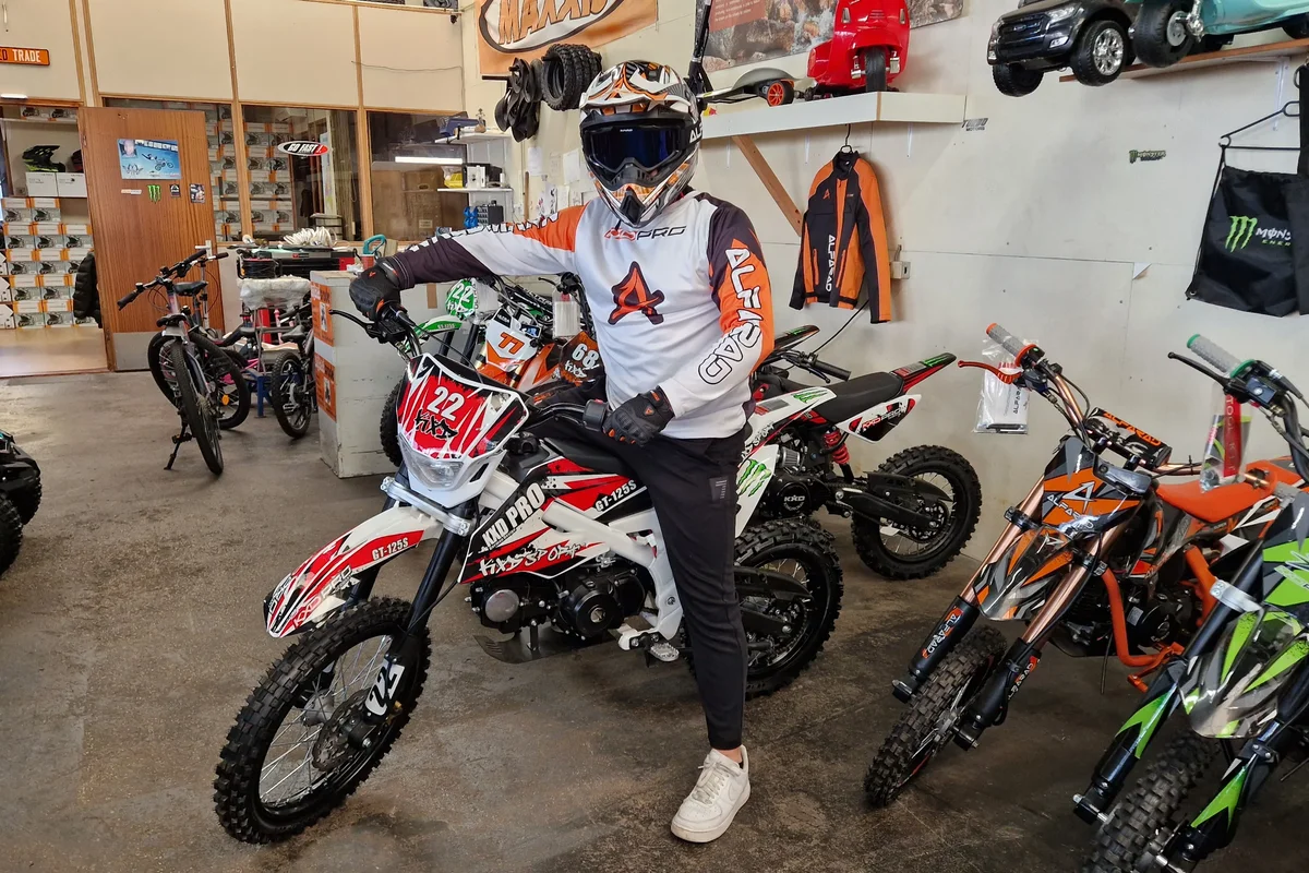 Rijder op een rood-witte pitbike in de showroom